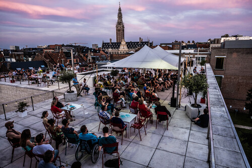 Dakterras van M Leuven in de zomer met tent met zonsondergang