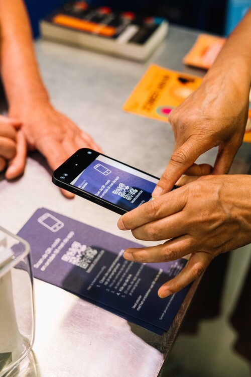 Bezoeker scant de QR-code om de app van M te gebruiken